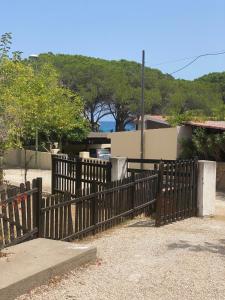 una valla de madera frente a una casa en Casa Cordelia, en Cala Liberotto
