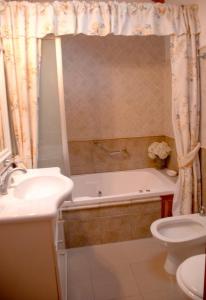 a bathroom with a tub and a toilet and a sink at Bungalows Maniu in San Carlos de Bariloche