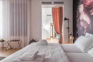 una camera da letto con un letto bianco e asciugamani di Blooms Botanical Rooms a Padova