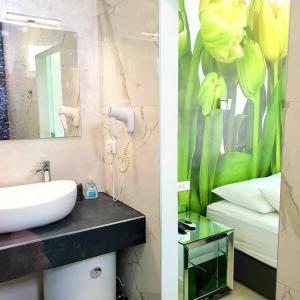 W łazience znajduje się umywalka i malowidło kwiatowe. w obiekcie Apartments Lomara w Dubrowniku