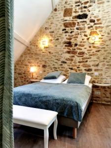 a bedroom with a bed and a stone wall at Casa Anca Deluxe in Sarlat-la-Canéda