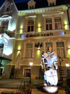 eine Statue vor einem Gebäude in der Nacht in der Unterkunft Edinburgh in Marienbad