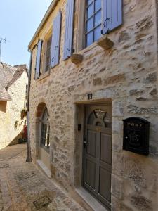 a stone building with a door in a street at Casa Anca Deluxe in Sarlat-la-Canéda