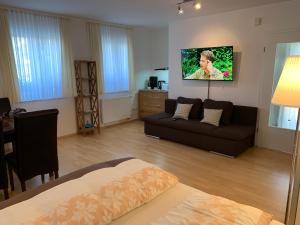 a living room with a couch and a tv on the wall at Ferienwohnung Schmitt in Lauf an der Pegnitz