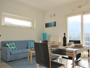 a living room with a table and a blue couch at Gardenia Apartment Ossuccio in Ossuccio