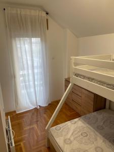 a bedroom with a bunk bed and a window at Apartman 12 Jelena Anžujska in Zlatibor