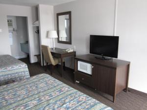 a hotel room with a television and a desk at Winsome Inn in Saint Stephen