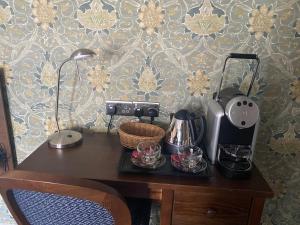 rooms @ the dolau inn في نيو كي: مكتب مع آلة صنع القهوة وغلاية الشاي