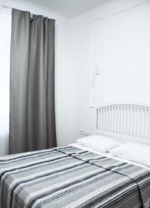 een slaapkamer met een bed met een grijs gordijn bij Residence Odesskij Dvorik in Odessa