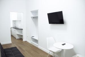 a living room with a table and a tv on a wall at Residence Odesskij Dvorik in Odesa