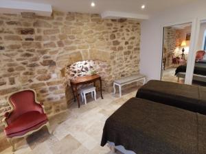 a bedroom with two beds and a stone wall at Casa Anca Deluxe in Sarlat-la-Canéda