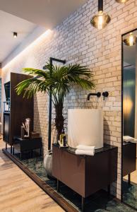ein Badezimmer mit einem Waschbecken und einer Topfpflanze in der Unterkunft Project 3 Urban Chic Hotel in Athen