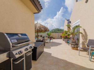 a outdoor kitchen with a grill and a patio at Golden Villas in Palm-Eagle Beach