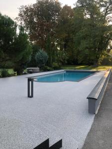 a swimming pool with a bench next to it at Le Pavillon de Nathalie in Isles-sur-Suippe