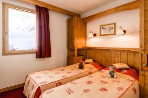 Rúm í herbergi á travelski home premium - Résidence Les Hauts de Comborcière 4 stars