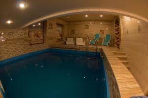 a swimming pool in a house with an arch over it at Ekaterinin Dvor Hotel in Surgut