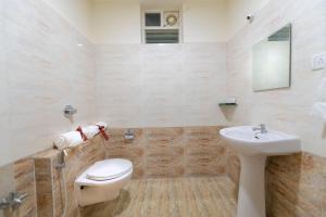 a bathroom with a toilet and a sink at Hotel BV Colours Bommanahalli in Bangalore