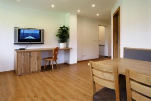 een woonkamer met een tafel en een televisie aan de muur bij Ferienwohnungen Josef Koll in Marktschellenberg