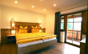 a bedroom with a bed with a wooden headboard and a window at Ferienwohnungen Josef Koll in Marktschellenberg
