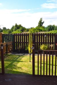 a wooden fence with a bench in the grass at Kelpies Serviced Apartments- Jamieson in Stenhousemuir