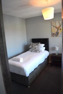 En eller flere senge i et værelse på Kelpies Serviced Apartments- Jamieson
