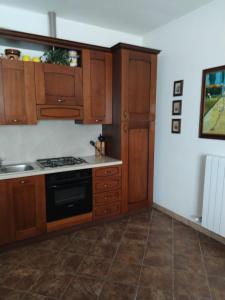 a kitchen with wooden cabinets and a stove top oven at Casa Elda in Galatone