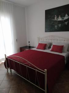 a bedroom with a large bed with red pillows at Casa Elda in Galatone