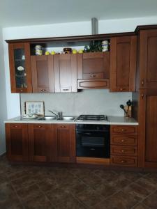 a kitchen with wooden cabinets and a stove at Casa Elda in Galatone