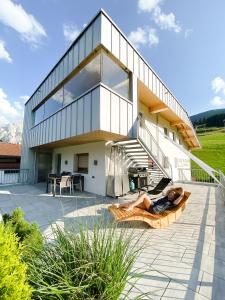 a person laying on a couch in front of a house at Haus am Schihang in Lermoos
