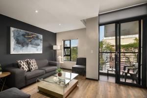 a living room with a couch and a glass table at Easy Stay - The Vantage Rosebank in Johannesburg