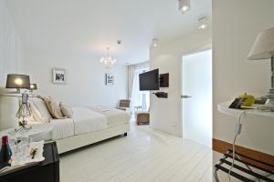 um quarto branco com uma cama e uma televisão em Hotel Saint-Amour em Durbuy
