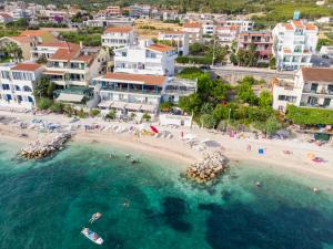 an aerial view of a beach with people in the water at Apartments Zanic on The Beach in Podstrana