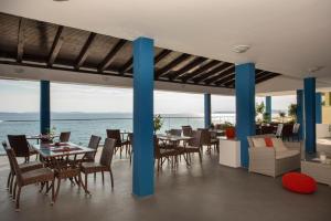 a restaurant with tables and chairs and a view of the water at Apartments Zanic on The Beach in Podstrana