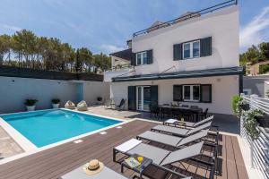une maison avec une piscine et des chaises dans l'établissement Luxury Villa Lara with a pool, à Milna