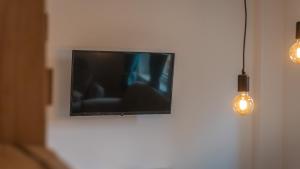 a flat screen tv hanging on a wall with lights at Appartementhaus- Bredner / Appartement IV in Rathmannsdorf