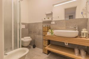 łazienka z umywalką, toaletą i lustrem w obiekcie Casa Camelia Varenna w mieście Varenna +29 zdjęć