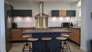 une cuisine avec un comptoir bleu et des tabourets dans l'établissement Gîte Les Vernes du Léman 11 à 13 pers, à Maxilly-sur-Léman