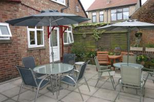 a patio with a table and chairs and umbrellas at The Bayridge Guest House in Bridlington