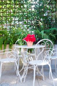 una mesa y sillas con una flor roja. en Apartments Sensa, en Dubrovnik