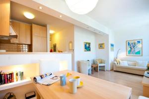 a kitchen and living room with a table and a couch at Apartments Sensa in Dubrovnik