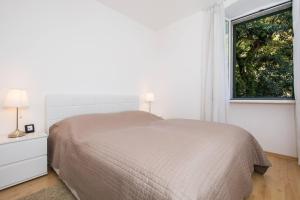 Un dormitorio blanco con una cama y una ventana. en Apartments Sensa, en Dubrovnik 41 fotos más