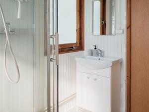 a bathroom with a sink and a shower with a mirror at Pustelnia Supraśl - domki nad rzeką in Supraśl