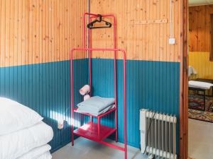 a room with a red towel rack next to a bed at Pustelnia Supraśl - domki nad rzeką in Supraśl