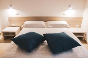 a bedroom with a large bed with two pillows on it at Verde Blu Vacanze B&B in Torre Lapillo