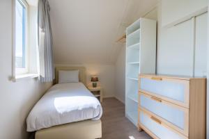 a small bedroom with a bed and a dresser at Antibes 258 - Kustpark Village Scaldia in Hoofdplaat