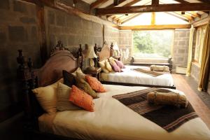 a bedroom with two beds with pillows on them at Hacienda Rumiloma by Rotamundos in Quito