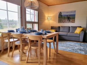 a dining room with a table and chairs and a couch at Rakovalkia Apartment in Saariselka