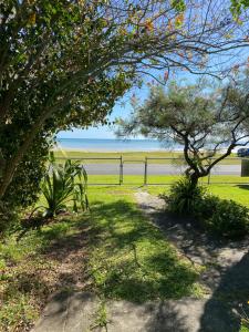 a path leading to a beach with a fence and trees at 35 Flinders Ave in Dunwich