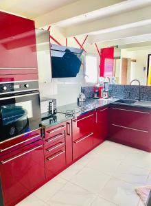 a red kitchen with red cabinets and appliances at #BBSH in Goussainville