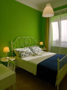 Dormitorio verde con cama con pared verde en B&B Stella Scugnizza en Nápoles